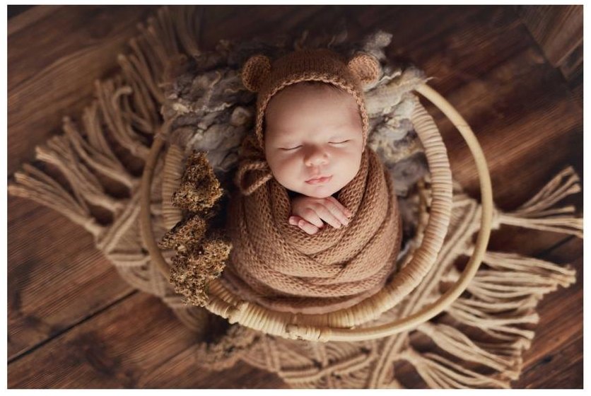 Slapende pasgeboren baby in een gebreid mutsje